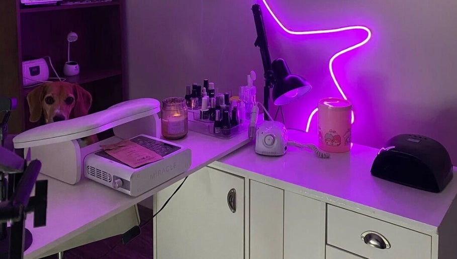 Mesa de manicura en Mariecure.nails, La Florida, Región Metropolitana, CL iluminada con luz púrpura y productos.