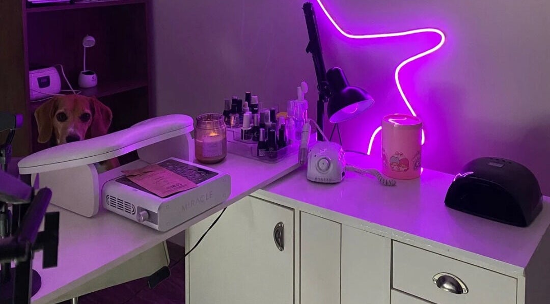 Mesa de manicura en Mariecure Nails, La Florida, Región Metropolitana, CL, iluminada con luces púrpura.