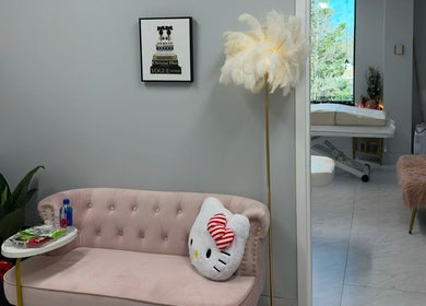 Elegant waiting area at Beauty Blossom, Woodbridge, Virginia, US, featuring a plush sofa and a whimsical decor.