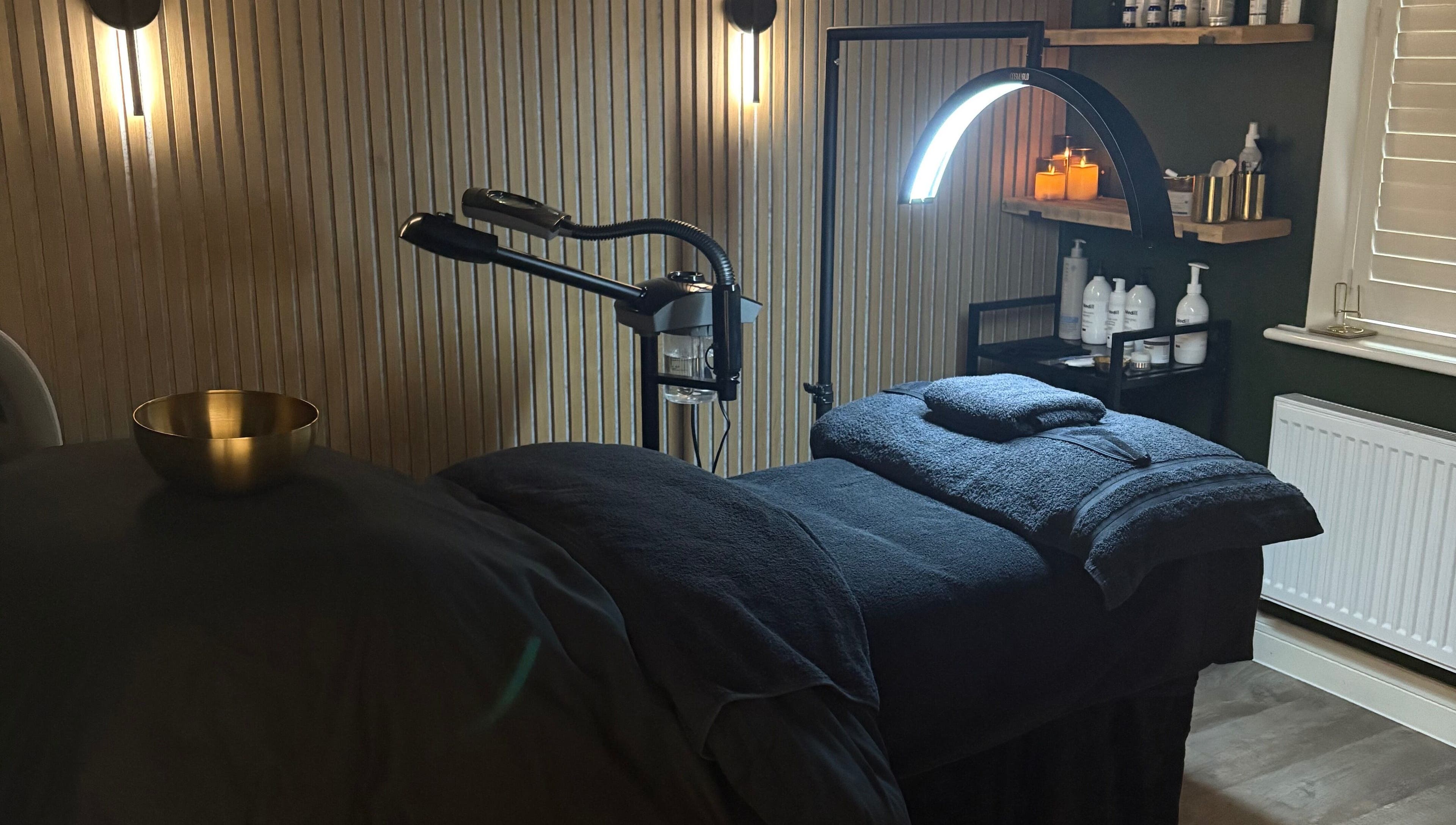 Relaxing treatment room at Glow and Renew Skincare, Ash, England, GB, with massage bed and ambient lighting.