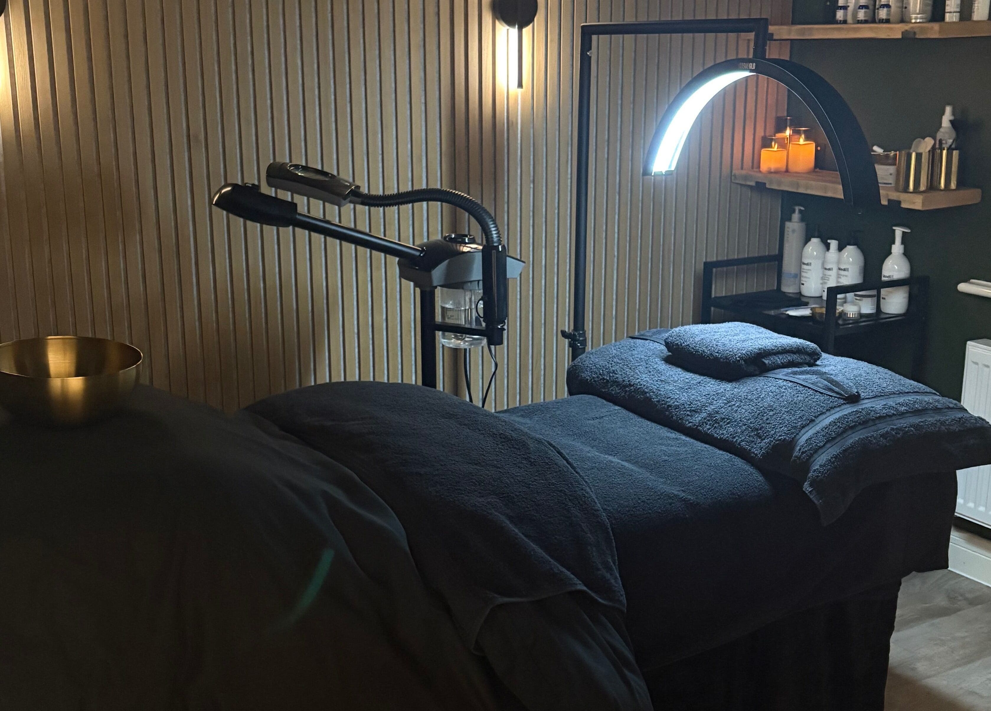 Relaxing treatment room at Glow and Renew Skincare, Ash, England, GB, with massage bed and ambient lighting.