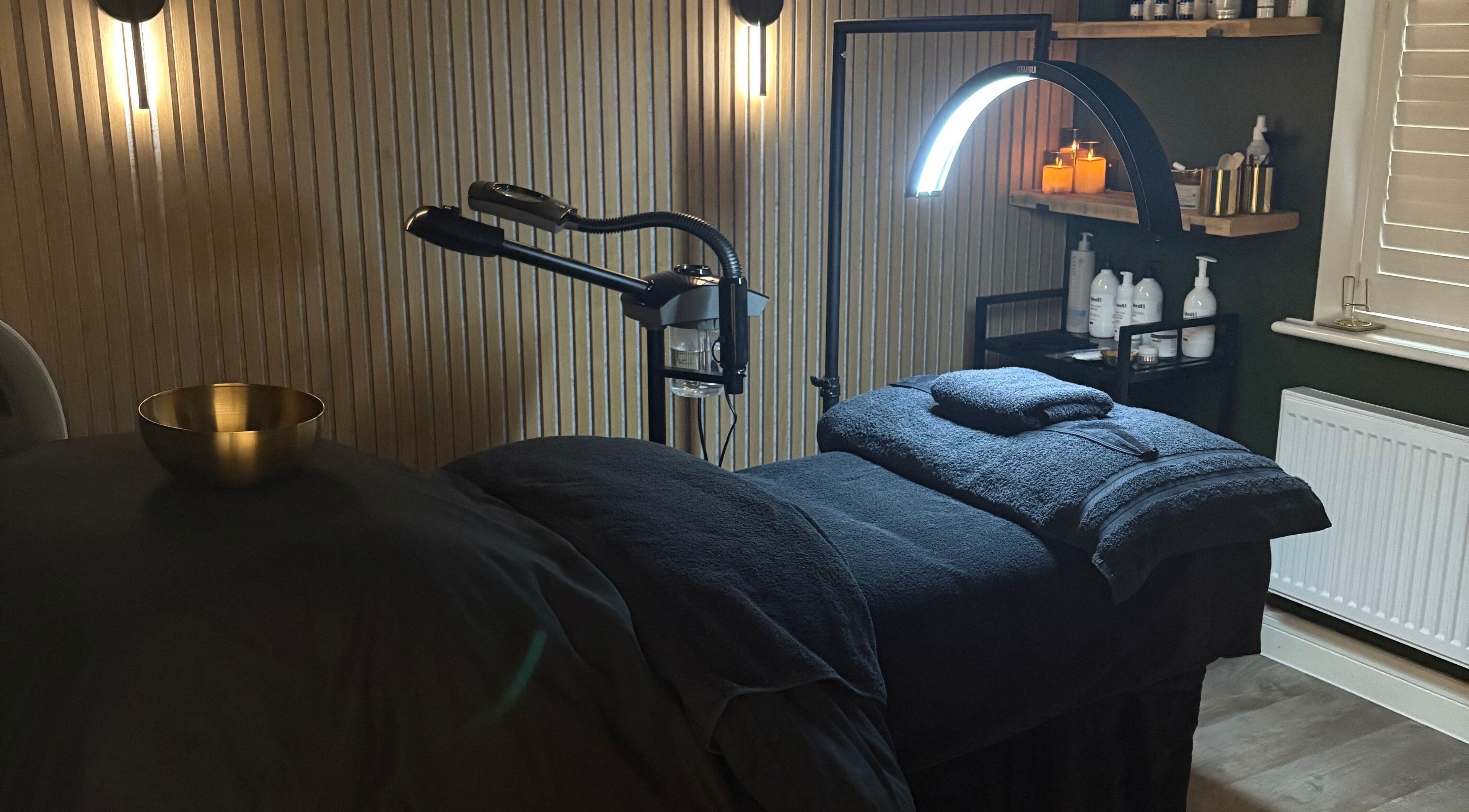 Relaxing treatment room at Glow and Renew Skincare, Ash, England, GB, with massage bed and ambient lighting.