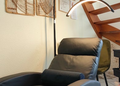 Fauteuil relaxant chez Studio Gapao, Village-neuf, Grand Est, FR, sous un escalier en bois.