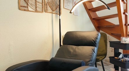 Fauteuil relaxant chez Studio Gapao, Village-neuf, Grand Est, FR, sous un escalier en bois.