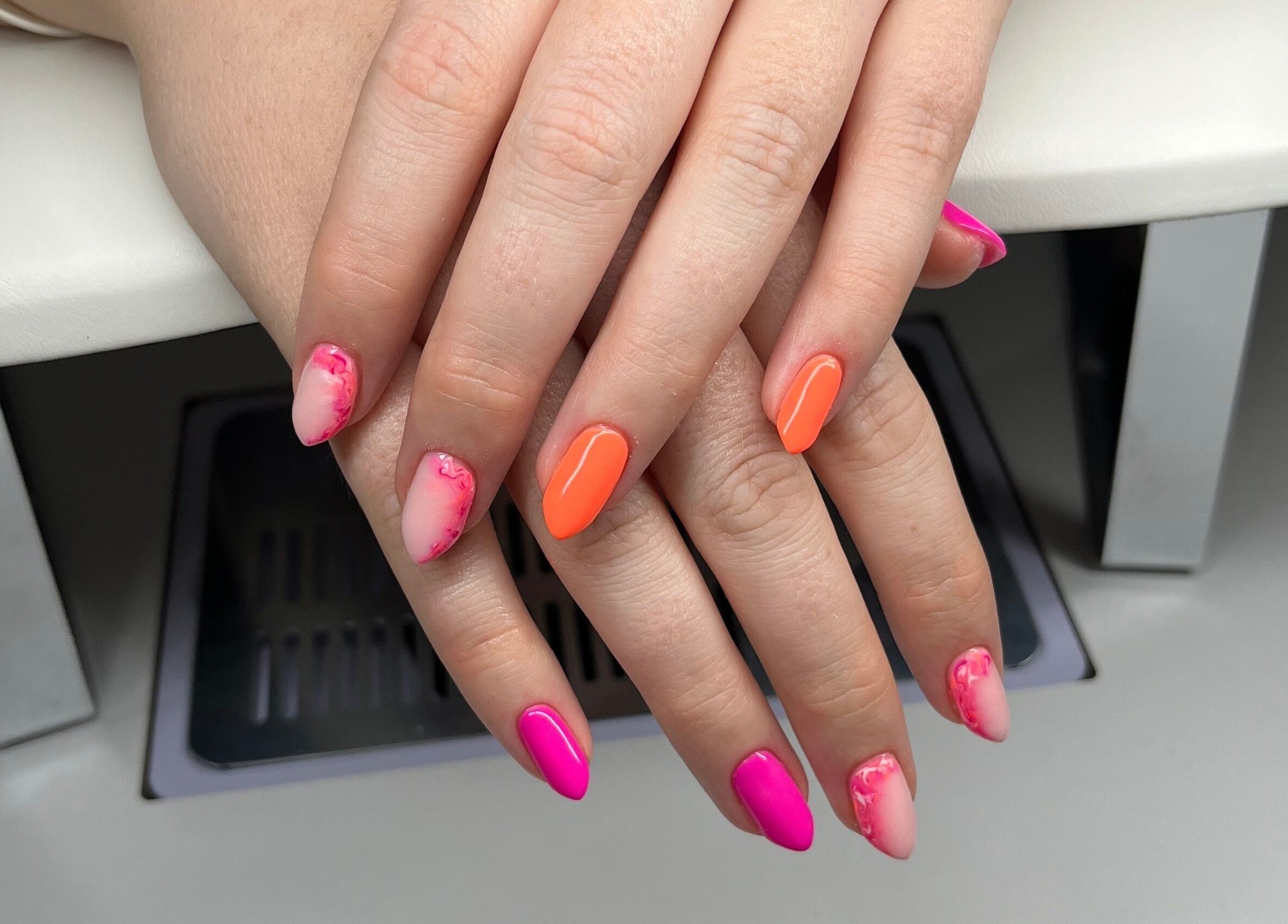 Colorful nail art at Studio 10 Beauty Boreham, Chelmsford, England, GB showcasing pink and orange designs.