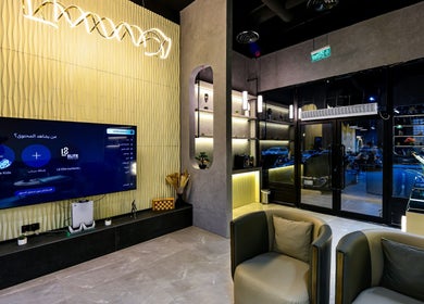 Chic interior of L8 Elite Barbershop in Riyadh, featuring modern seating and illuminated displays.
