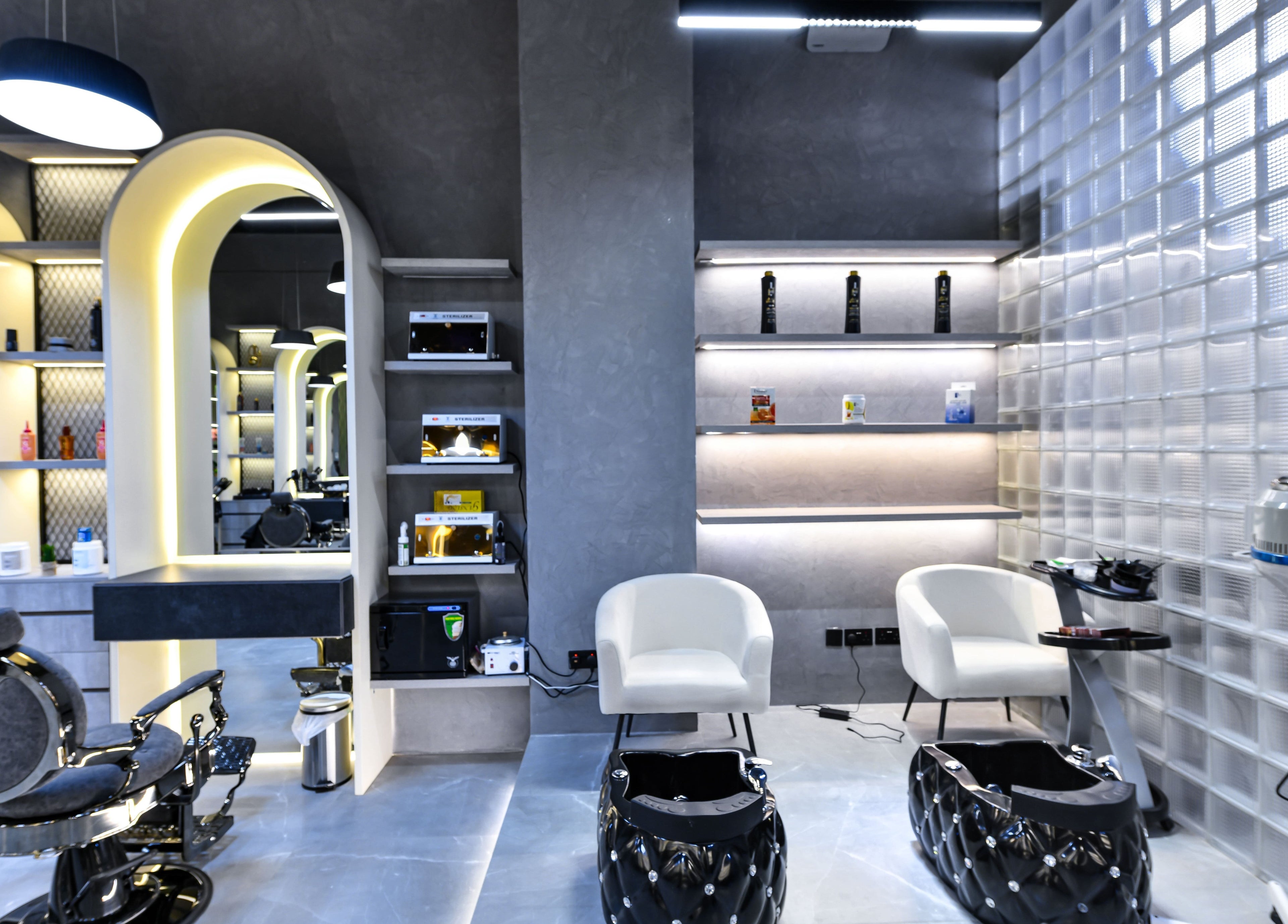 Modern interior of L8 Elite Barbershop, Riyadh, Riyadh Province, SA featuring chic chairs and illuminated shelves.