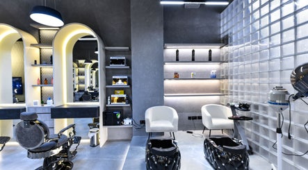 Modern interior of L8 Elite Barbershop, Riyadh, Riyadh Province, SA featuring chic chairs and illuminated shelves.