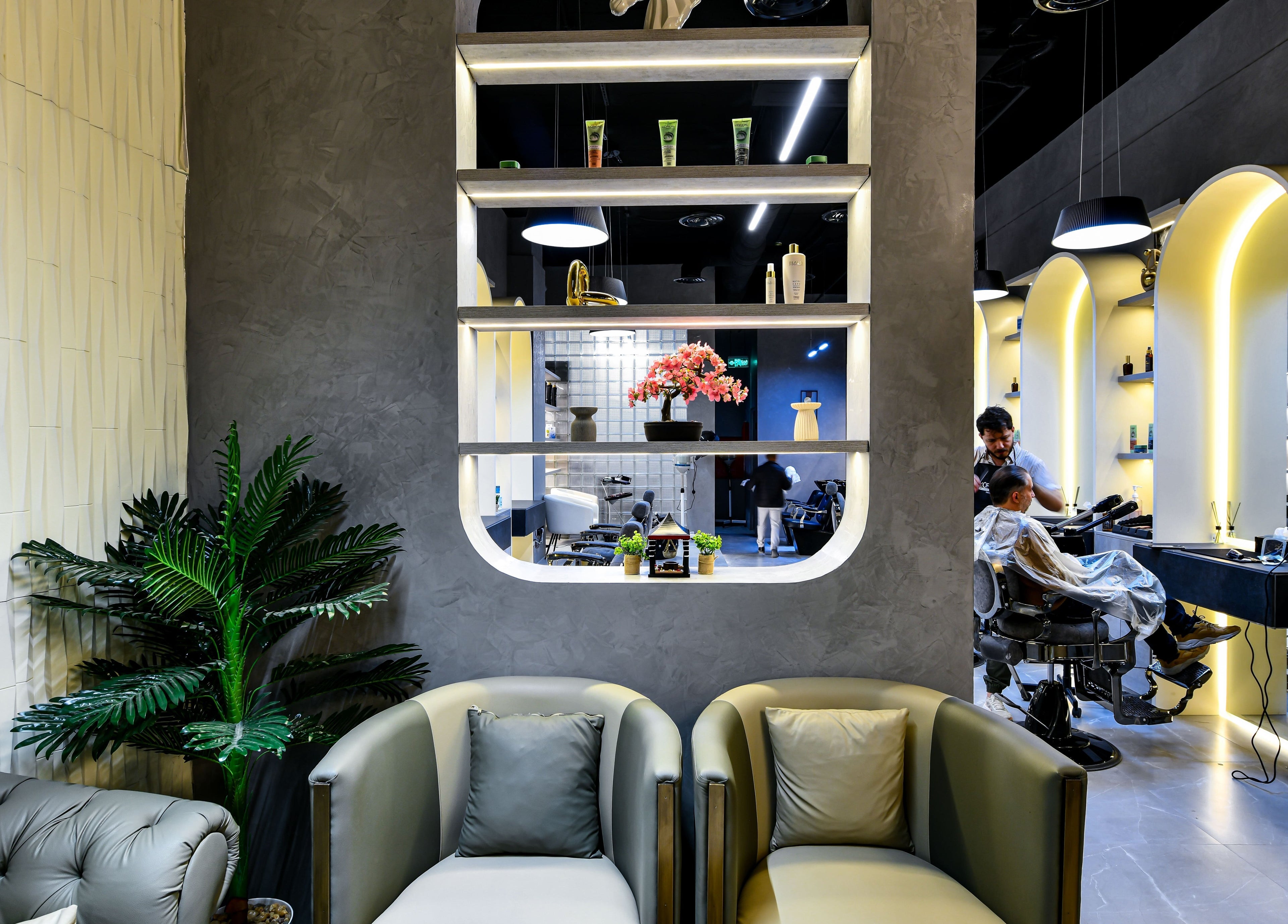 Stylish interior of L8 Elite Barbershop in Riyadh, with modern decor and barber at work.