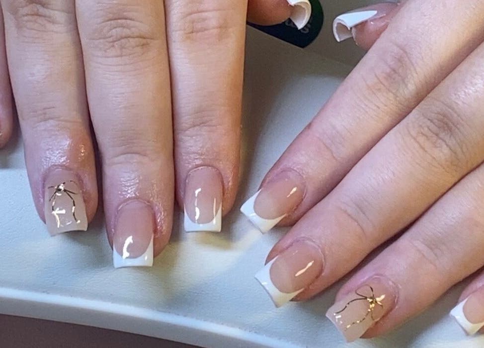 Stylish French manicure with gold accents at ONYX Nails & Beauty, Worsley, England, GB.