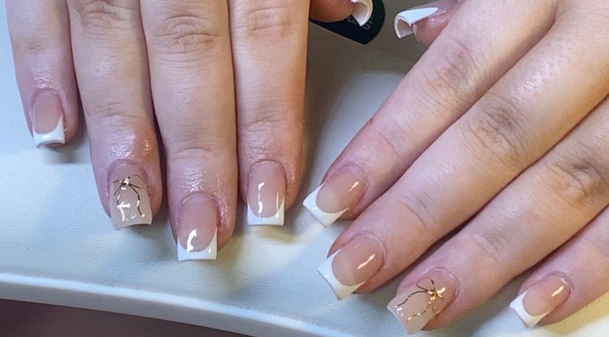 Stylish French manicure with gold accents at ONYX Nails & Beauty, Worsley, England, GB.