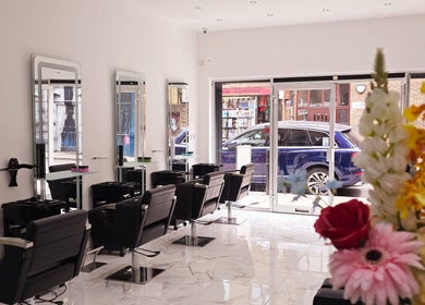 Chic interior of London City Hair Salon Limited, London, England, GB, featuring stylish chairs and flower decor.