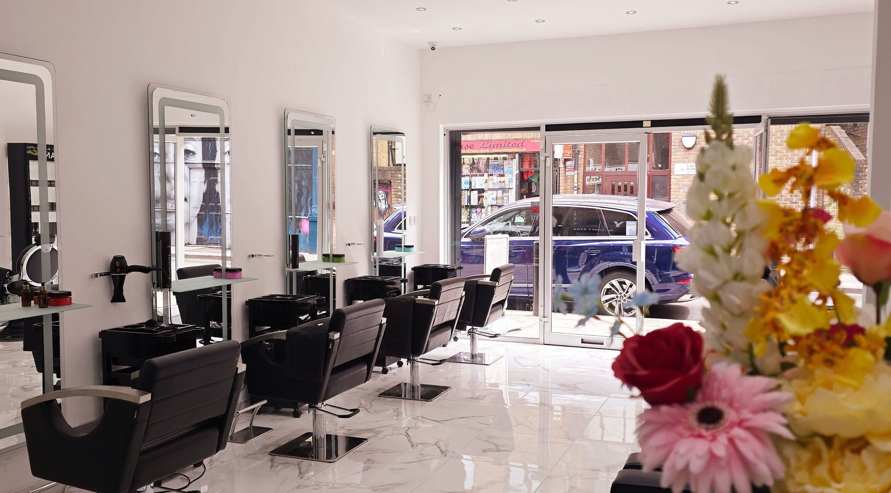 Chic interior of London City Hair Salon Limited, London, England, GB, featuring stylish chairs and flower decor.