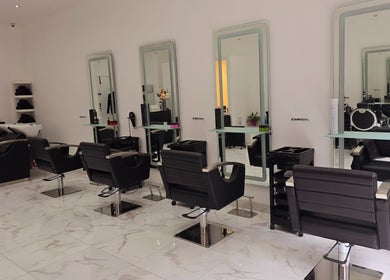 Bright, modern salon interior at London City Hair Salon Limited in London, England, GB with stylish black chairs.