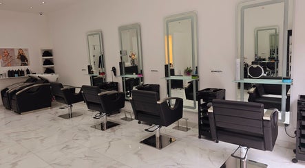 Bright, modern salon interior at London City Hair Salon Limited in London, England, GB with stylish black chairs.