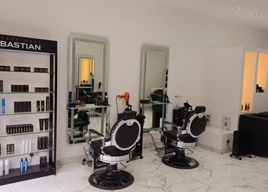 Modern interior of London City Hair Salon Limited with styling chairs and product display, London, England, GB.