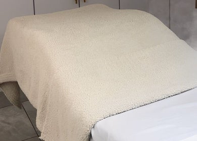 Cama de masaje con toalla suave en Pieles en Calma, Gurabo, PR, creando un ambiente relajante.