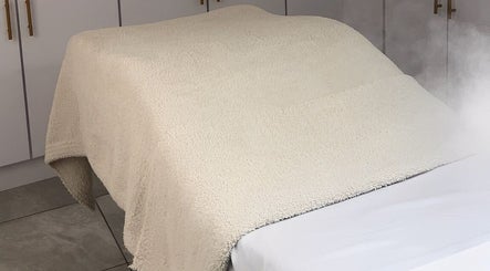 Cama de masaje con toalla suave en Pieles en Calma, Gurabo, PR, creando un ambiente relajante.