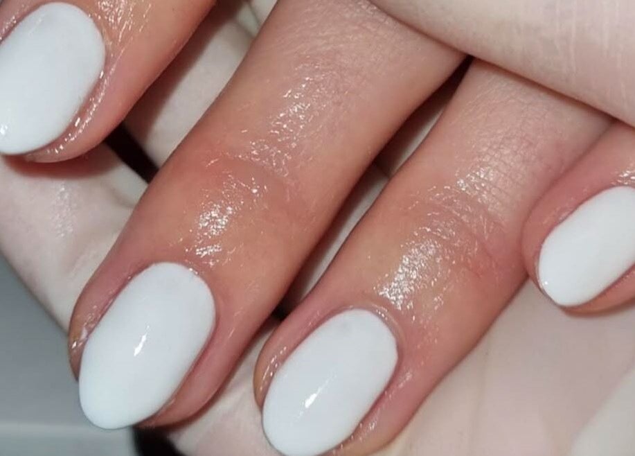 Close-up of polished white nails at Pinky Bar, Bristol, England, GB. Perfectly manicured hands.