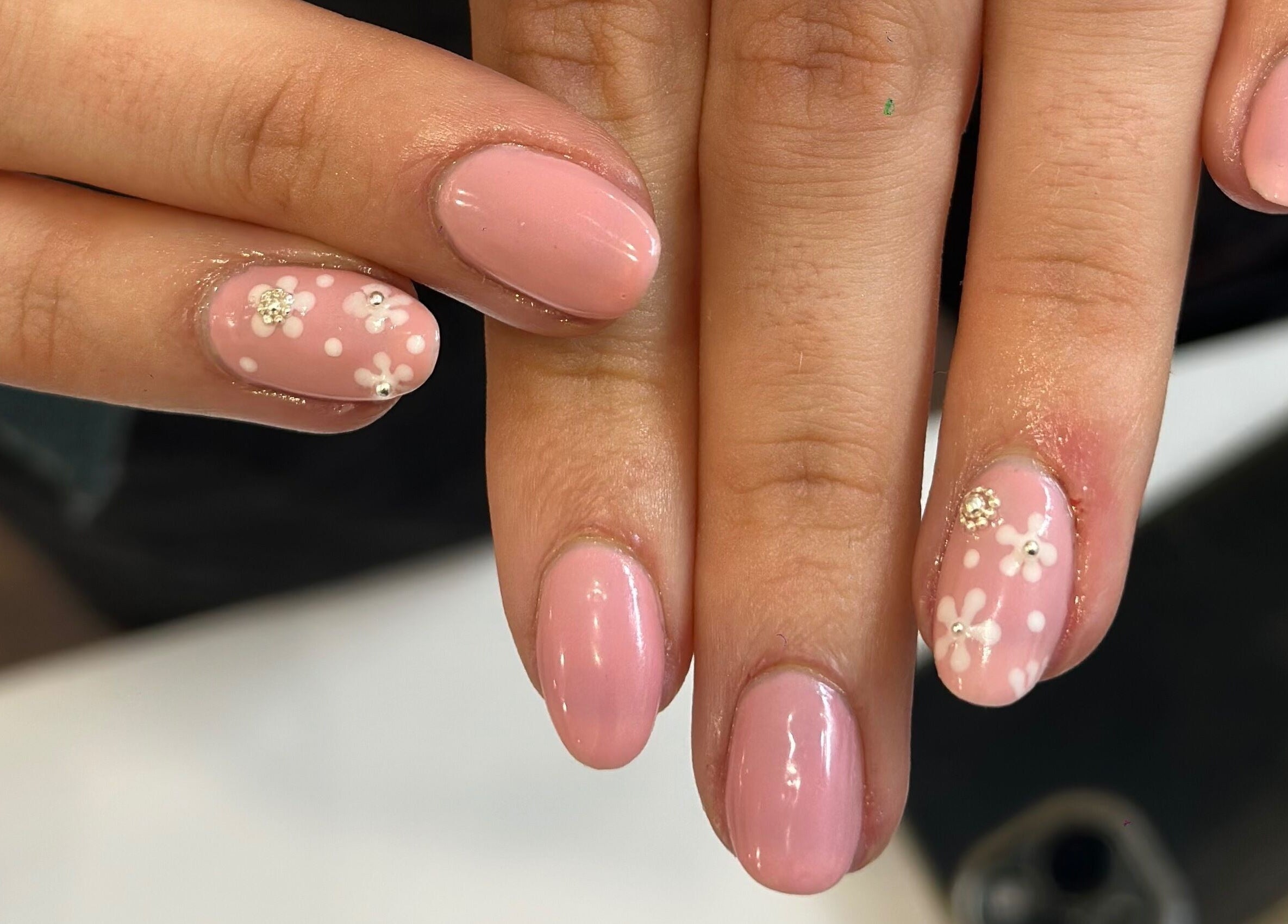 Delicate floral nail art at Pinky Bar, Bristol, England, GB, showcasing pink polish with white flowers.