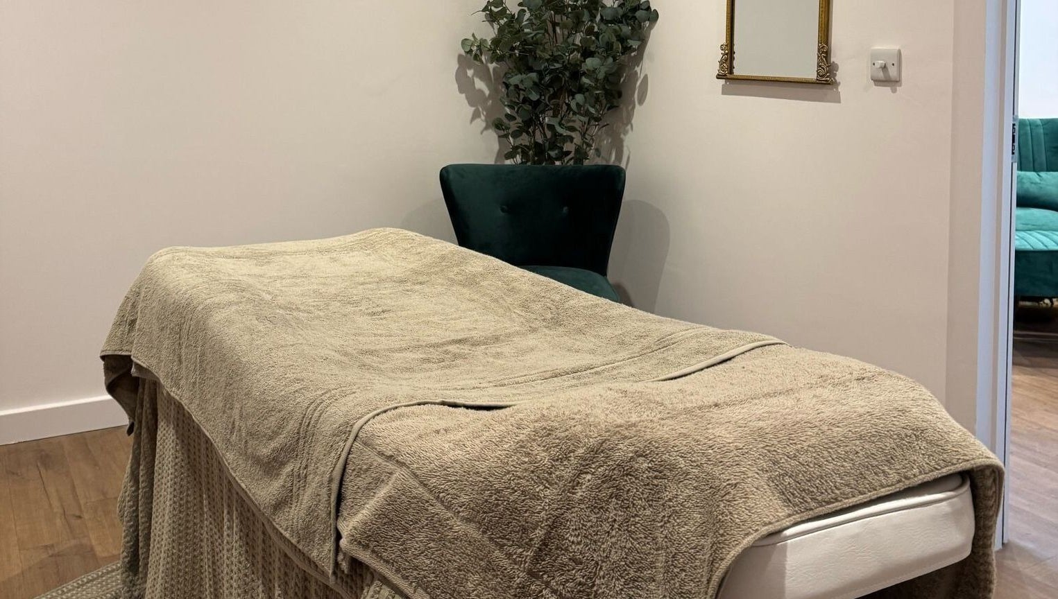 Relaxing massage room at Belle, Otley, England, GB featuring a cozy treatment bed and elegant decor.