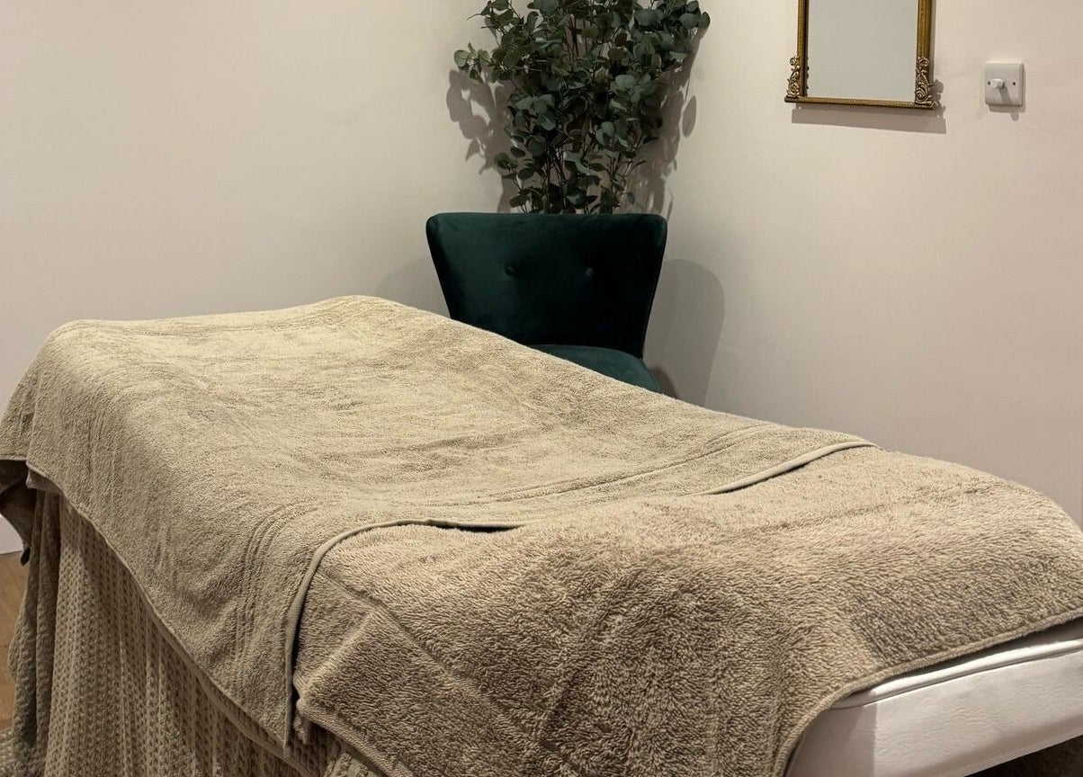 Relaxing massage room at Belle, Otley, England, GB featuring a cozy treatment bed and elegant decor.