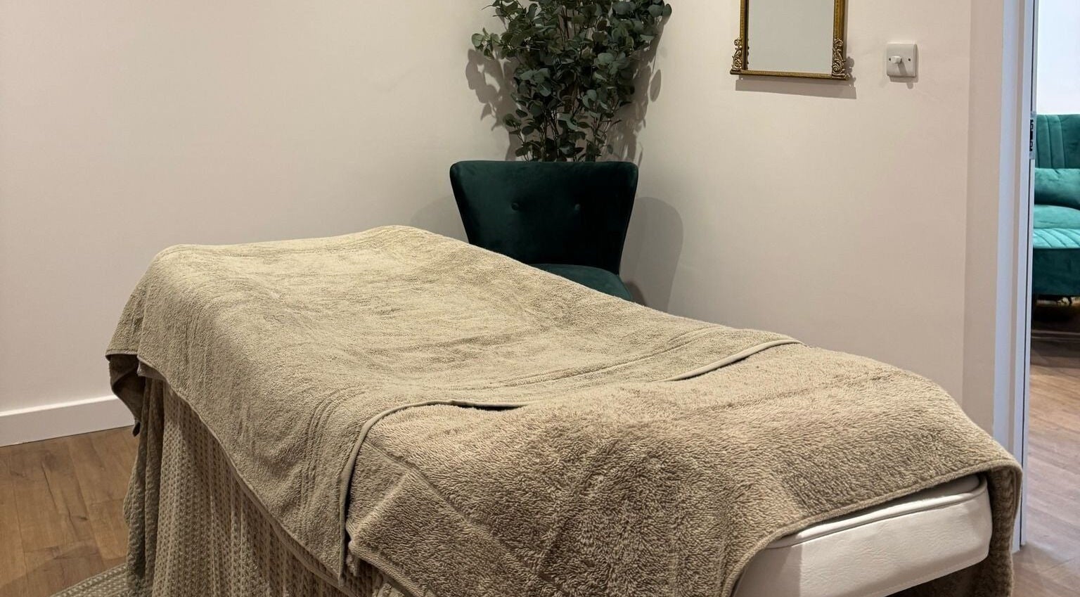 Relaxing massage room at Belle, Otley, England, GB featuring a cozy treatment bed and elegant decor.