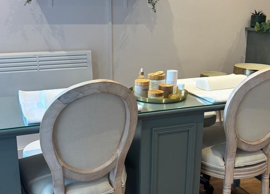Elegant spa table setup at Belle, Otley, England, GB, with plush chairs and skincare products.