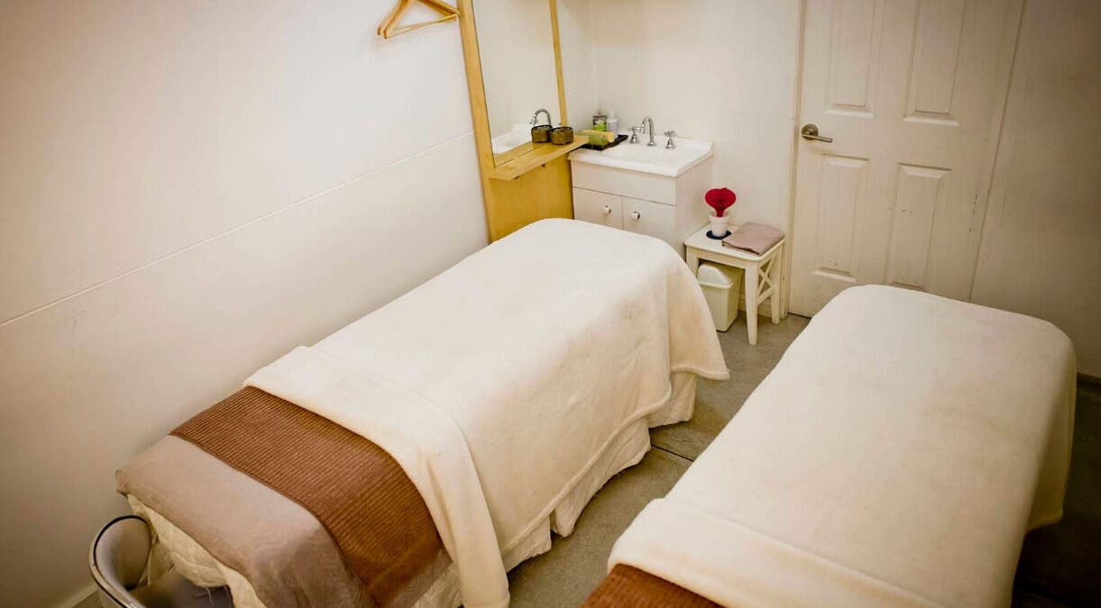 Relaxing massage room at Inner Beauty Sydney in Chatswood, New South Wales, AU with two beds and soft lighting.