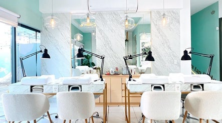 Espacio elegante en Jomare Nail Spa, Zapopan, Jalisco, MX, con mesas de mármol y lámparas modernas.