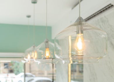 Lámparas colgantes iluminan el interior de Nail Spa Jomare en Zapopan, Jalisco, MX, creando un ambiente acogedor.
