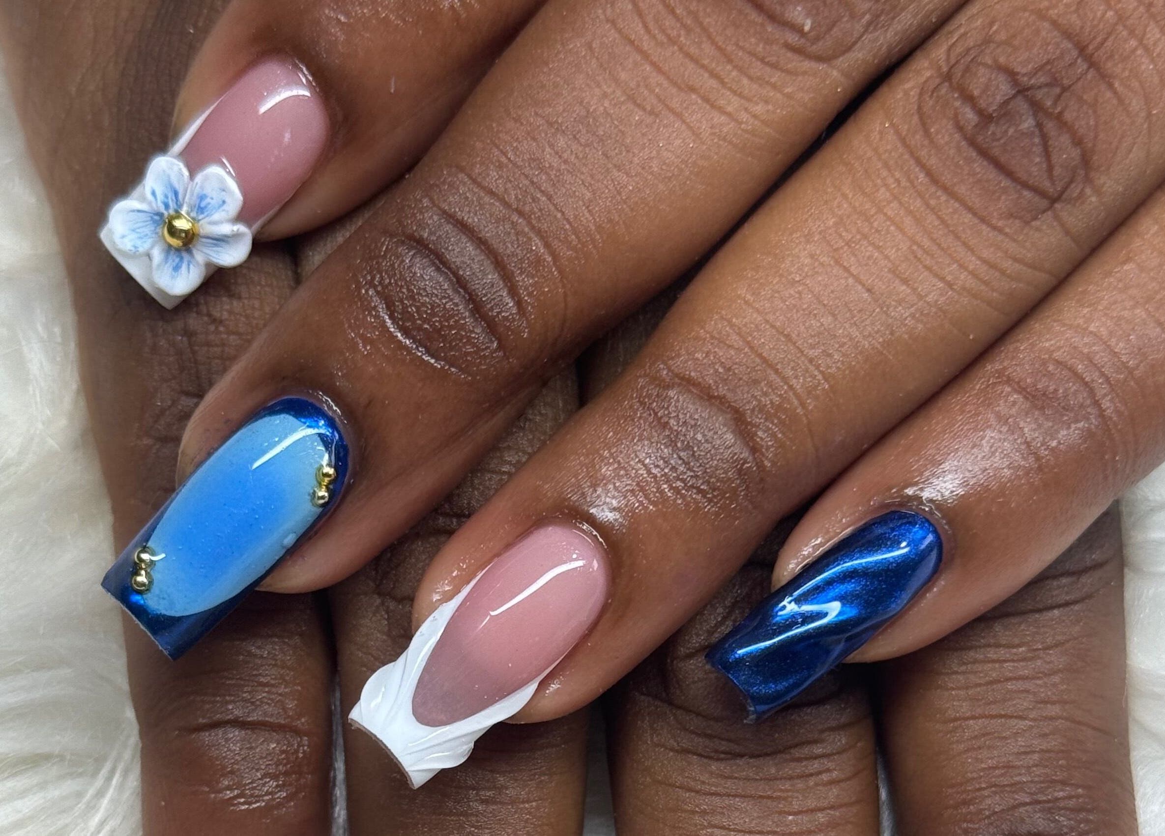 Stylish blue and floral nail art from Nails by Dark.Indi in Kingston, St. Andrew Parish, JM on a cozy backdrop.
