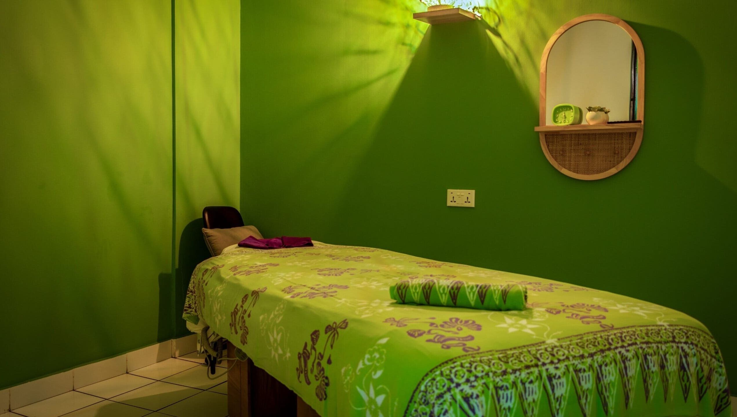 Relaxing green spa room at The Spa in Díli, Dili, TL, featuring a massage bed and calming decor.