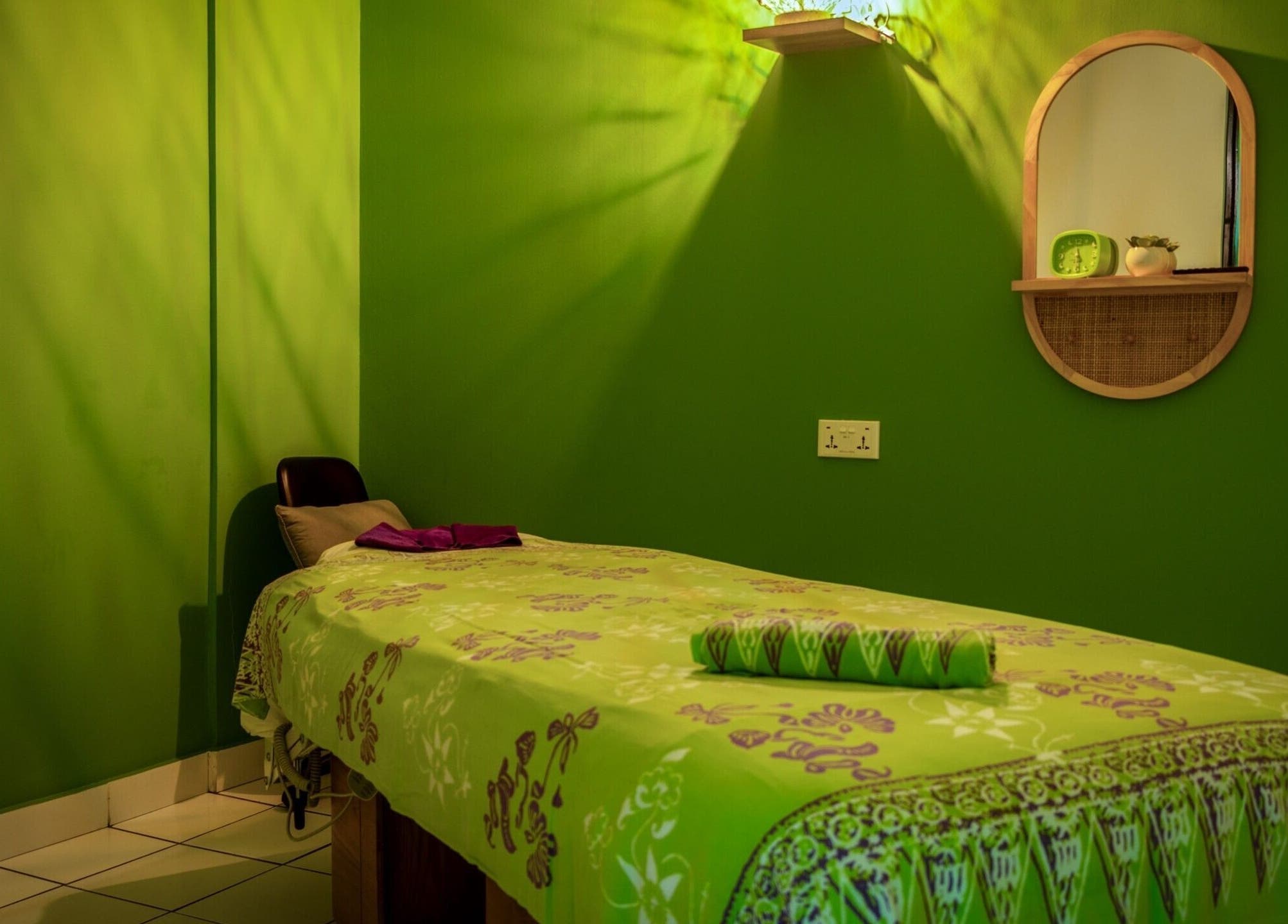 Relaxing green spa room at The Spa in Díli, Dili, TL, featuring a massage bed and calming decor.