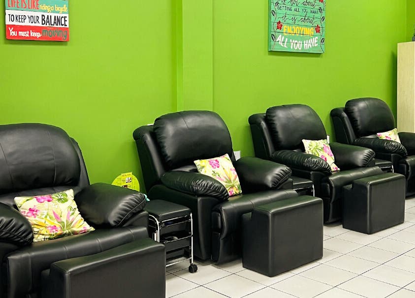Cozy massage chairs at The Spa, Díli, Dili, TL provide ultimate relaxation in a serene green setting.