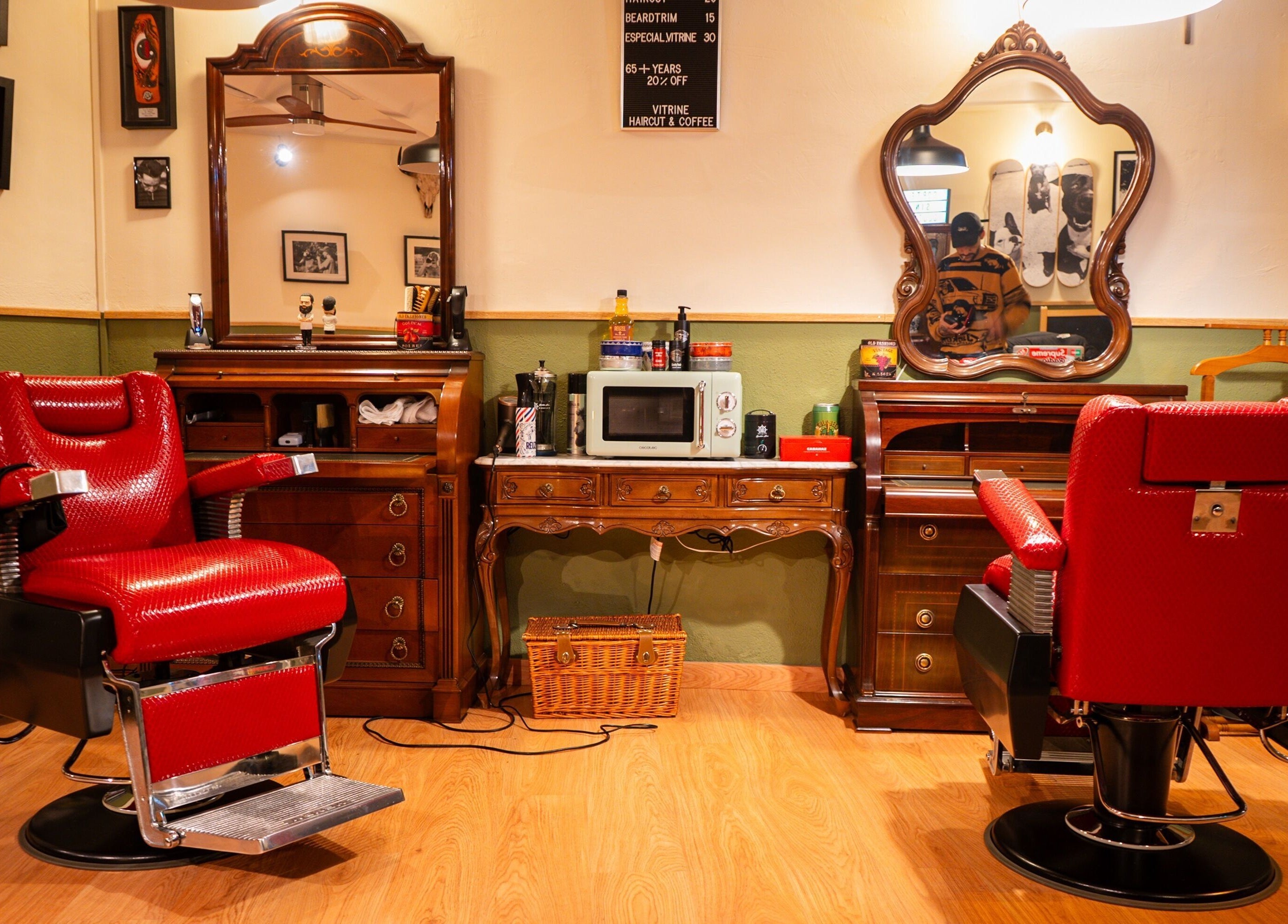 Interior de Vitrine Tradicional Barber en Barcelona, Catalunya, ES, con sillas rojas y espejos antiguos.