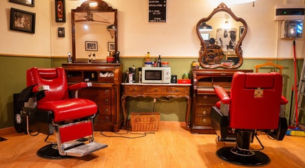 Interior de Vitrine Tradicional Barber en Barcelona, Catalunya, ES, con sillas rojas y espejos antiguos.