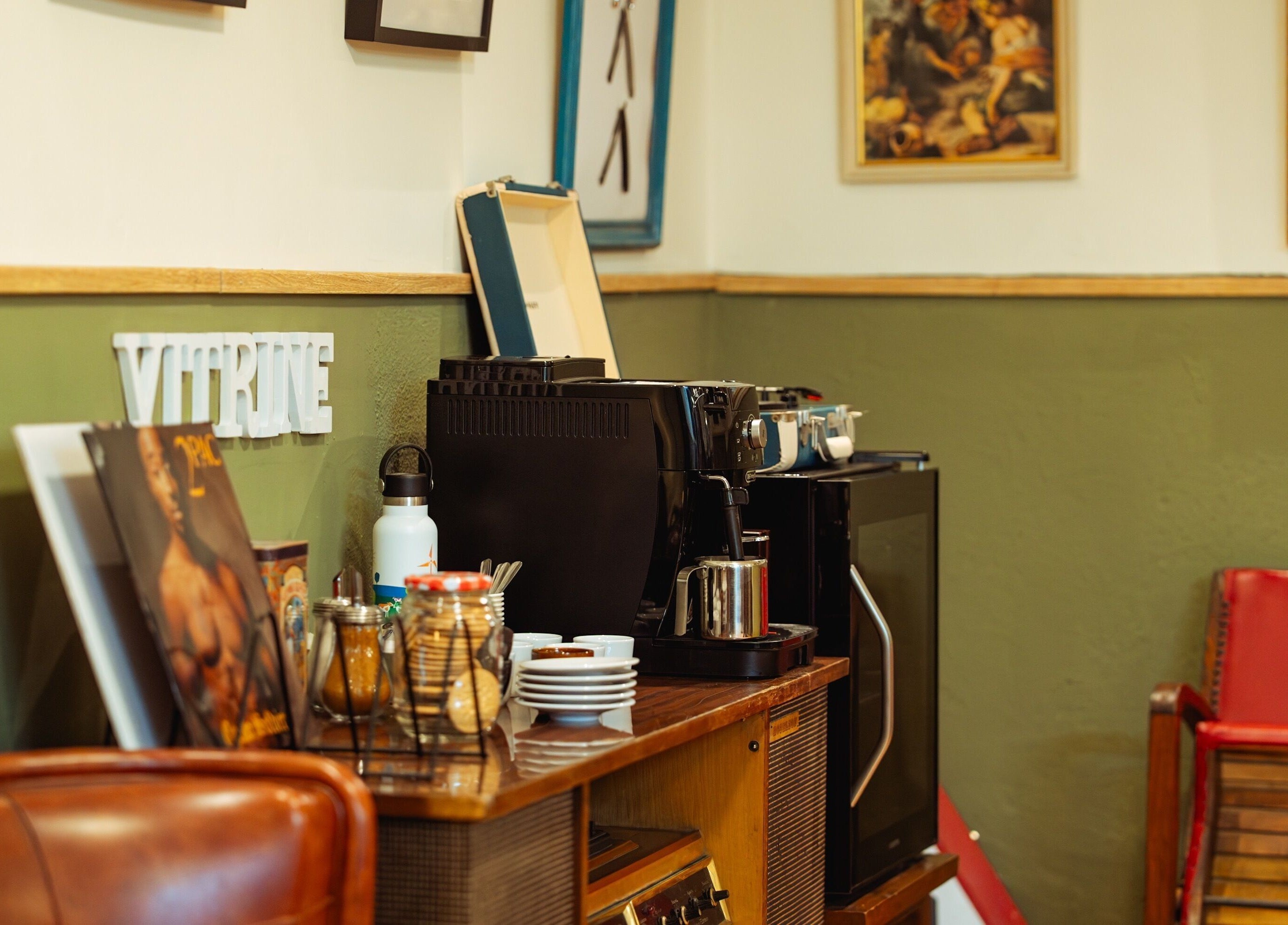 Interior acogedor de Vitrine Tradicional Barber en Barcelona, Catalunya, ES con estación de café y decoración vintage.