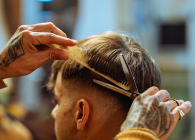 Un barbero cortando el cabello en Vitrine Tradicional Barber, Barcelona, Catalunya, ES.
