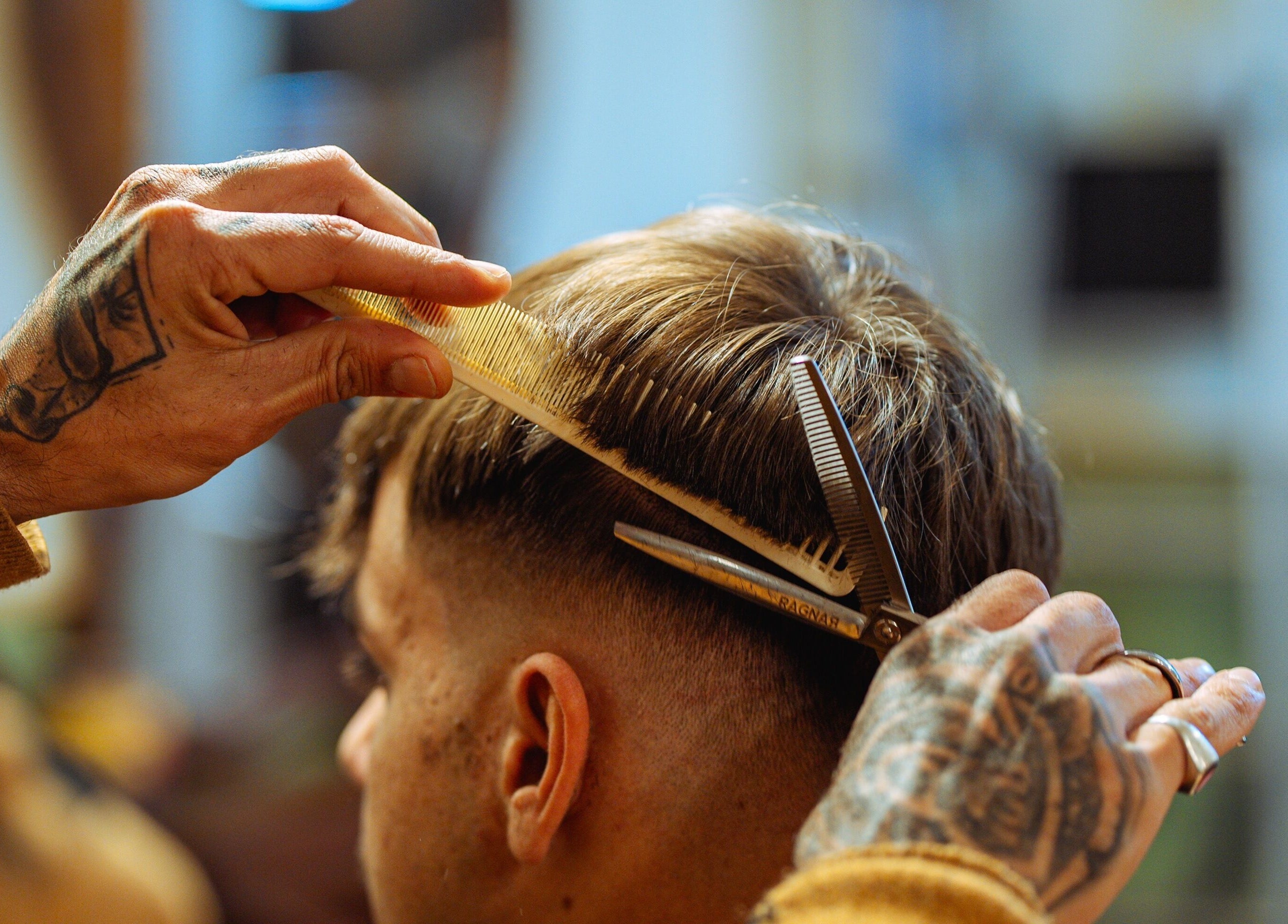 Un barbero cortando el cabello en Vitrine Tradicional Barber, Barcelona, Catalunya, ES.