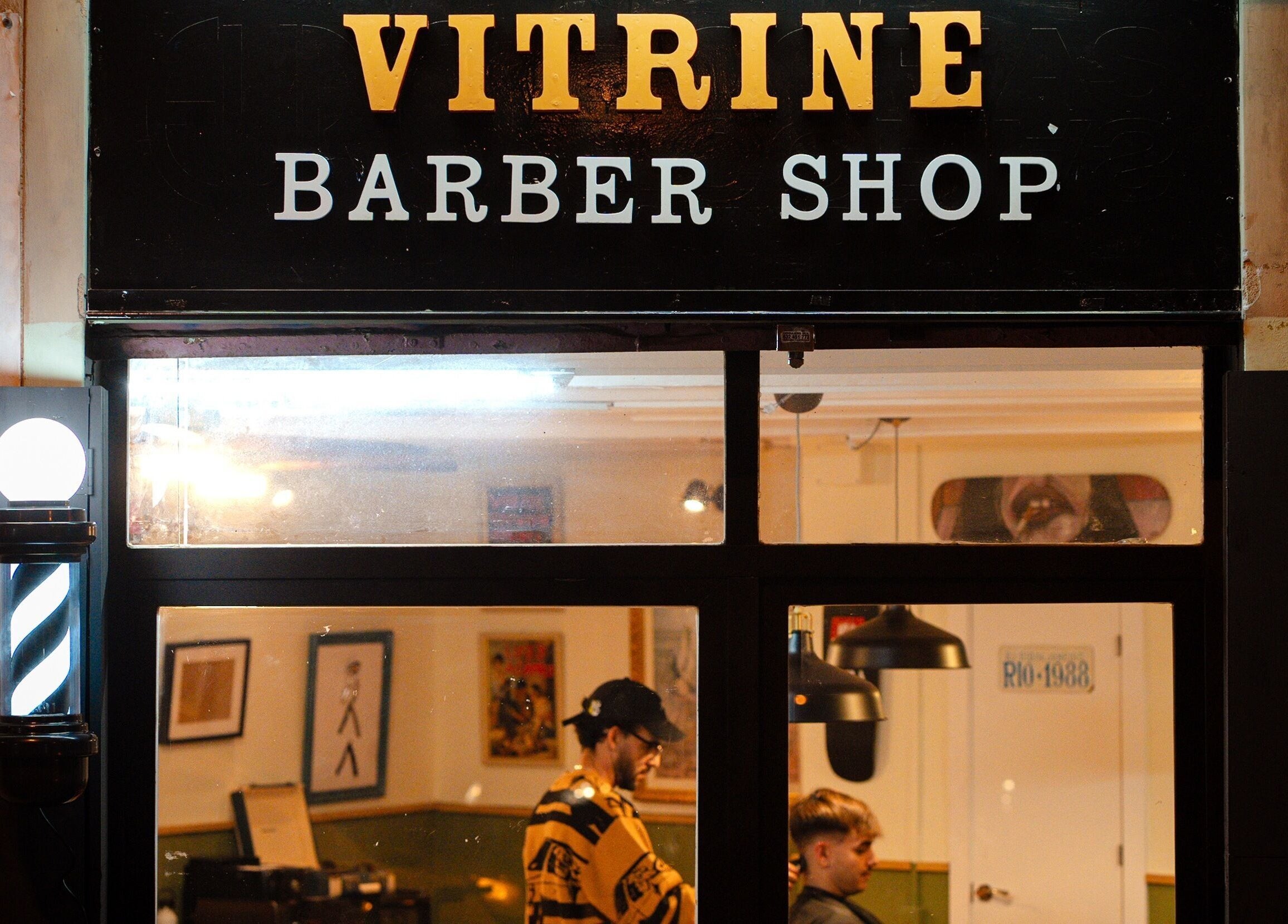 Fachada iluminada de Vitrine Tradicional Barber en Barcelona, Catalunya, ES, vista desde la calle.