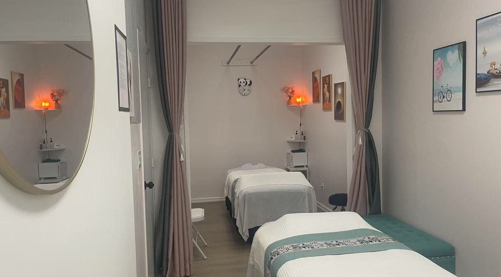 Relaxing massage room at Village SPA, Palm City, Florida, US, with two beds, warm lighting, and elegant decor.