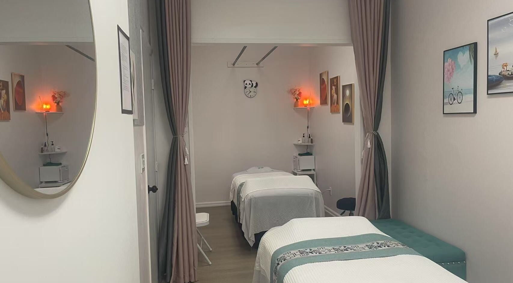 Relaxing massage room at Village SPA, Palm City, Florida, US, with two beds, warm lighting, and elegant decor.