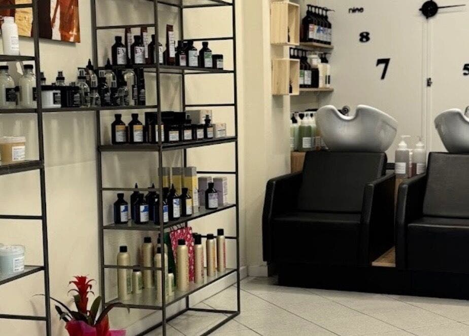 Interno di Hair Salon di Creatura Giada a Modena, Emilia-romagna, IT, con prodotti esposti e sedie lavatesta.