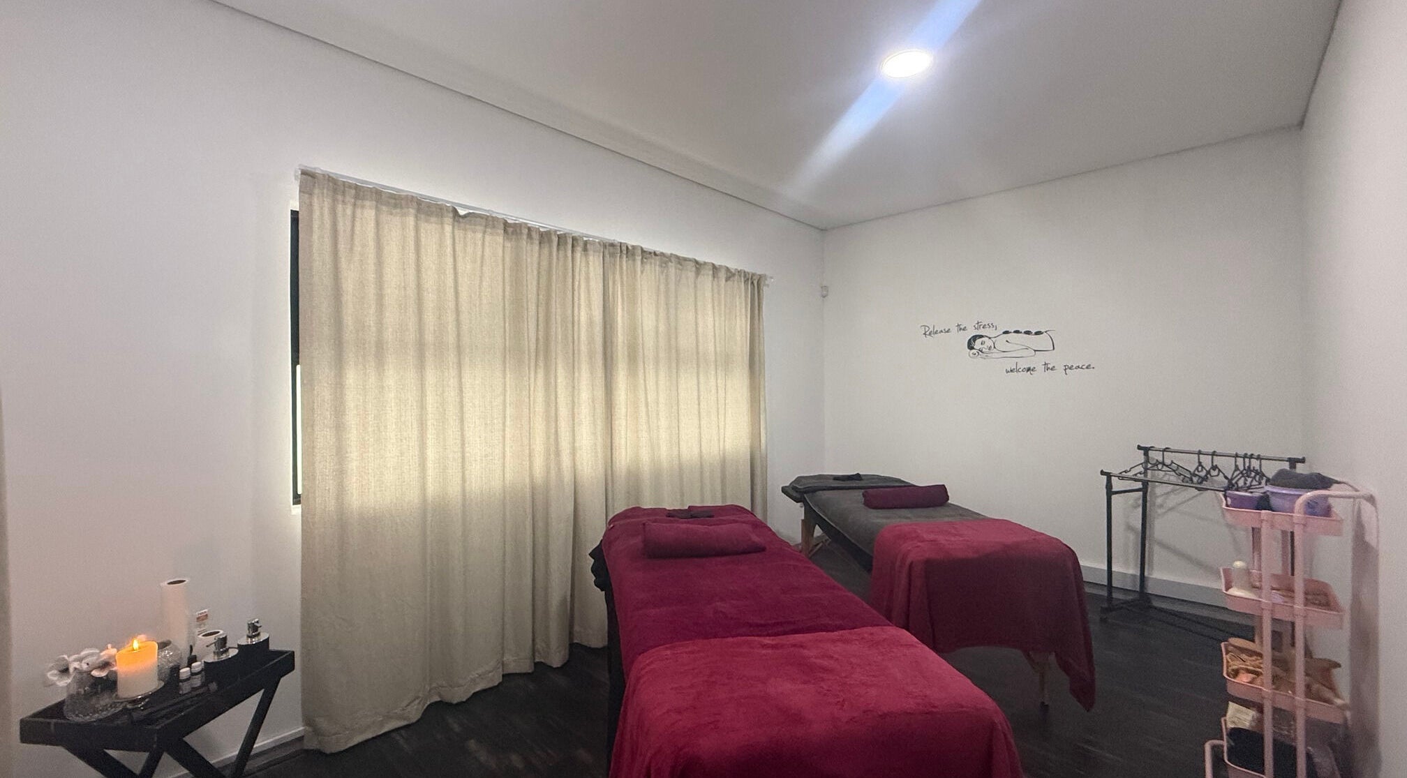 Massage room with red linens at Beauty Defined By Cindy G in Gqeberha, Eastern Cape, ZA.