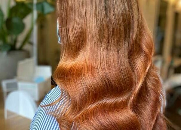 Luxurious wavy hairstyle at Hair by Boom, Edinburgh, Scotland, GB, showcasing vibrant copper tones.