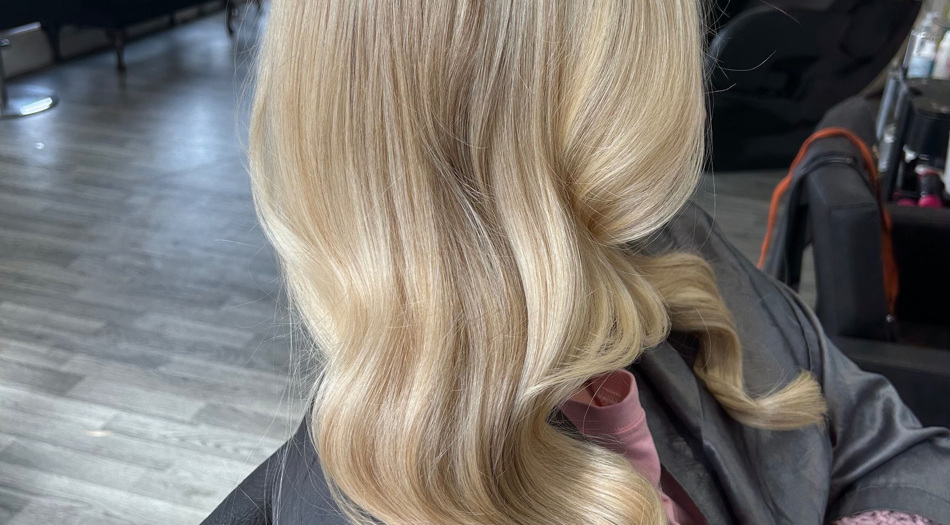 Soft blonde waves styled at Hairapeutic by Gabs in Wigan, England. Sophisticated hair design for modern elegance.