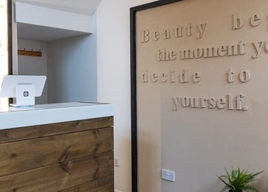 Reception desk at Gaia Wellness in Berkswell, England, GB, featuring a motivational quote on the wall.