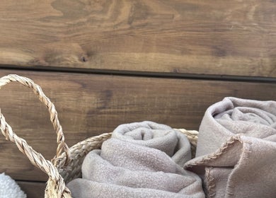 Rolled towels in a woven basket at Gaia Wellness, Berkswell, England, GB, showcasing natural spa ambiance.