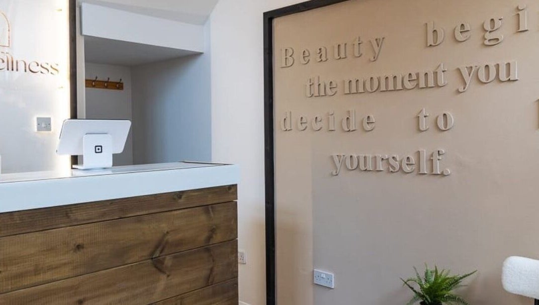 Reception area of Gaia Wellness, Berkswell, England, with inspiring wall quote and wooden desk.